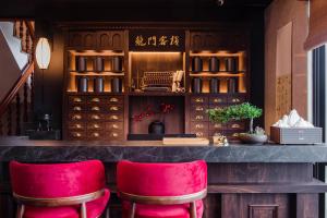 九份H& Jiufen The Dragon Inn的餐厅内带红色酒吧凳的酒吧