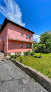 萨拉热窝波斯尼亚豪斯宾馆的前面有草地的粉红色房子