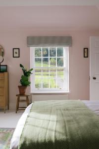 HawardenGardener's House - Hawarden Estate的一间卧室设有一张绿色的床和一个窗户。