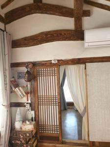 全州市Gugangjae Hanok Stay的一间设有一扇门的房间,通往一个设有天花板的房间