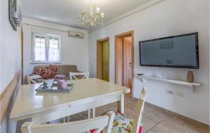 普拉Cozy Apartment In Pula With Wifi的一间带桌子和平面电视的用餐室