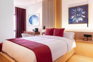 加的斯Boutique Hotel OLOM - Only Adults recommended的一间卧室配有一张带红色枕头的大床