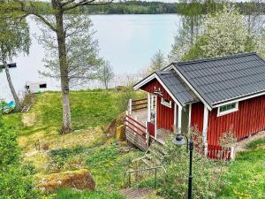 林雪平Holiday home LINKÖPING II的湖畔小山上的红色小屋