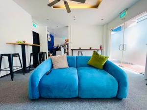 新加坡Beary Best! Hostel Chinatown的一张蓝色沙发,配有枕头,位于房间里