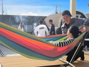 Itoshimaitotoi 糸島的躺在吊床上的男人和孩子