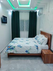 达喀尔Studio Emeraude - cosy et climatisé - Résidence Saraba Mermoz的一间卧室配有一张绿灯床