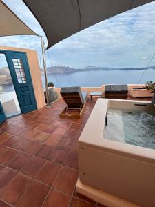 伊亚Horizon Aeifos Suites的享有水景的天井上的热水浴池