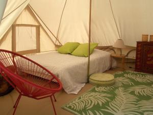 Cléry-Saint-AndréCamping du Petit Gué du Roi的一间卧室配有带一张床和椅子的帐篷