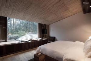 杭州杭州枫眠私享客栈的一间卧室设有一张大床和一个大窗户