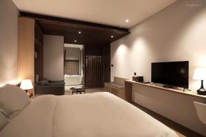 杭州杭州枫眠私享客栈的一间卧室配有一张床和一台平面电视