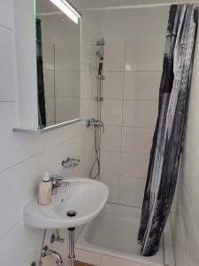 赖弗尼茨Gästehaus Rosl的浴室配有盥洗盆、镜子和浴缸