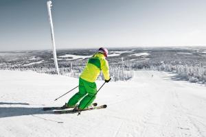 鲁卡Ski-Inn RukaSuites的一个人在雪覆盖的斜坡上滑雪