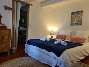 法扬斯La Ferme Constantin的一间卧室配有一张大床,提供蓝色的床单和枕头