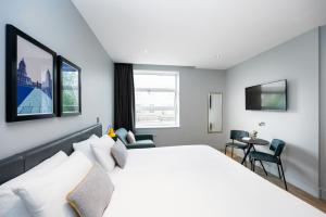 伦敦Staycity Aparthotels London Greenwich High Road的卧室配有一张白色的大床和一张桌子