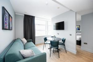 伦敦Staycity Aparthotels London Greenwich High Road的客厅配有沙发和桌子