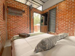 怡保Tingkat Valley的卧室设有一张砖墙内的大床