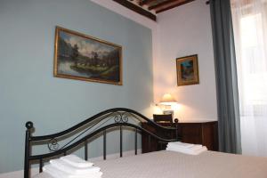 皮蒂利亚诺Il Girasole Storico的卧室配有一张床,墙上挂有绘画作品