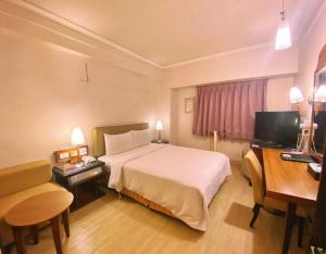 高雄種子商旅的酒店客房设有一张大床和一张书桌。