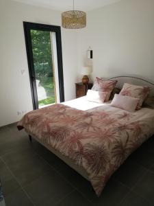 乌尔坦Charmante Maison neuve au Lac d'Hourtin的卧室配有一张带粉红色枕头的大床