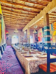 OuzinaPorte De Sahara Ouzina的大型用餐室配有长桌和椅子