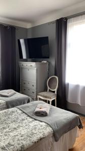 斯克伦达Skrunda Apartments Elvira的一间卧室配有两张床、一个梳妆台和椅子