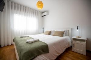 比索达雷加Lino's Family的白色的卧室设有一张白色大床和一个窗户。