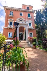 罗马Mangili Garden Hotel的粉红色的房子前面有楼梯和植物