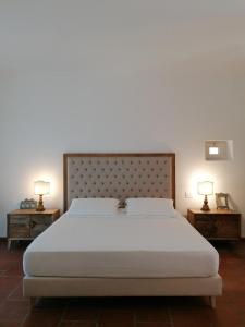 奥特朗托帕拉佐德摩利酒店的一间卧室配有一张带2个床头柜的大型白色床