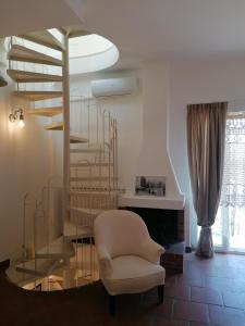 奥特朗托帕拉佐德摩利酒店的客厅设有螺旋楼梯和椅子