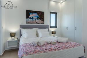 佩里沃罗Villa Basilica Kalavria的卧室配有带毛巾的大型白色床