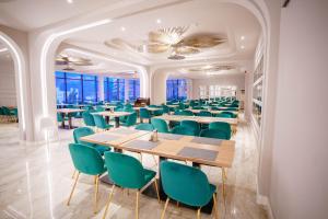 伯伊莱海尔库拉内Bacolux Afrodita Resort & SPA, Herculane的用餐室配有桌子和绿色椅子