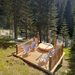 Goreljek维拉特里格拉芙波克卢卡旅馆的一个带两把椅子的木制甲板和热水浴缸