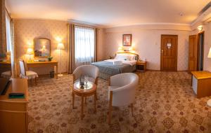 乌兰巴托Continental Hotel的酒店客房带一张床、一张桌子和椅子