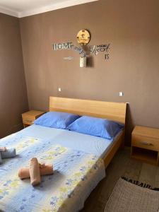 萨利Island paradise Lavdara的一间卧室配有一张蓝色床单和墙上的时钟。
