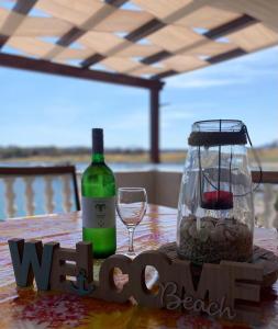 萨利Island paradise Lavdara的一张桌子,上面放着一瓶葡萄酒和一杯
