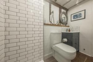 WenhastonWell Green Cottage的白色瓷砖浴室设有卫生间和镜子