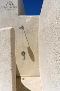 佩里沃罗Villa Basilica Tefsia的石墙,有金属勺子从里面伸出来