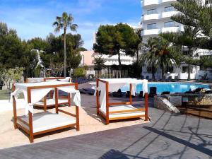 帕尔马海滩BG Pamplona的游泳池畔的两把椅子和一张桌子
