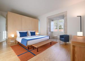 阿尔科巴萨Montebelo Mosteiro de Alcobaça Historic Hotel的一间卧室配有一张带蓝色枕头的大床