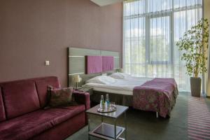 克拉科夫中心商务酒店的酒店客房,配有床和沙发