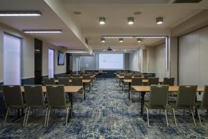 克拉科夫中心商务酒店的一间会议室,配有桌椅和白板