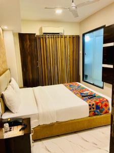 孟买Hotel Embassy Park - BKC Mumbai的一间卧室设有一张大床和一个窗户。
