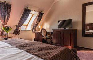 克罗梅日什Hotel Octarna - Free parking的配有一张床和一台平面电视的酒店客房