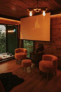 ArdeşenPavri suit bungalov的客厅配有两把椅子和投影屏幕