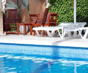 埃斯卡纳玛瓦韦尔塔旅馆的一组椅子和桌子,位于游泳池旁