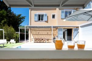圣特罗佩Villa Acacias - Au coeur de Saint-Tropez的两杯橙汁坐在房子前面的桌子上