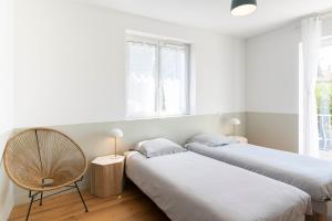 圣特罗佩Villa Acacias - Au coeur de Saint-Tropez的一间设有两张床和椅子的房间