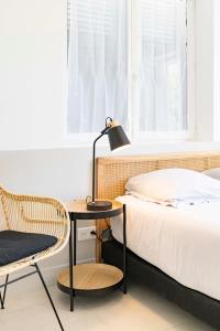 圣特罗佩Villa Acacias - Au coeur de Saint-Tropez的卧室配有1张床、1张桌子和1把椅子