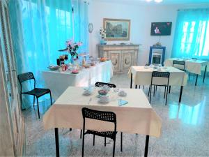 泰尔莫利B & B Villa Fiorella的一间设有白色桌椅的用餐室