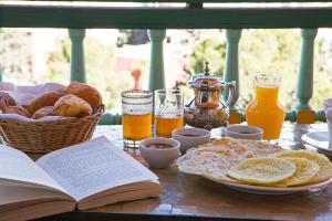 马拉喀什萨阿迪马拉喀什度假酒店的一张桌子,上面放着一本开放式的书,还有面包和橙汁